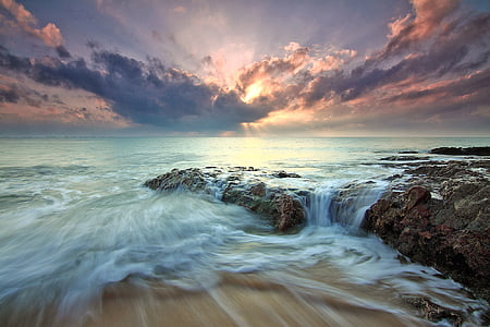 time lapse photography of rock and body of water thumbnail