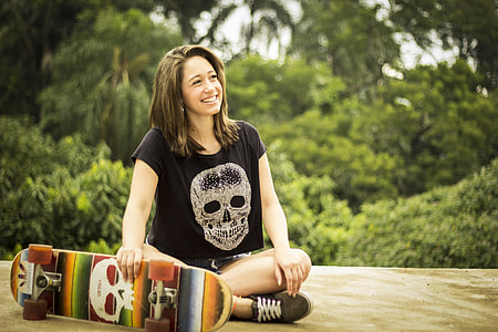 woman sitting while holding skateboard thumbnail