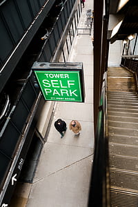 two men walking under Tower Self Park signage thumbnail