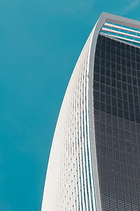 white and grey high rise building under clear blue sky thumbnail