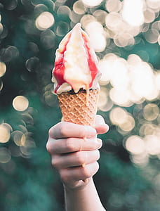 person holding ice cream in cone during daytime thumbnail