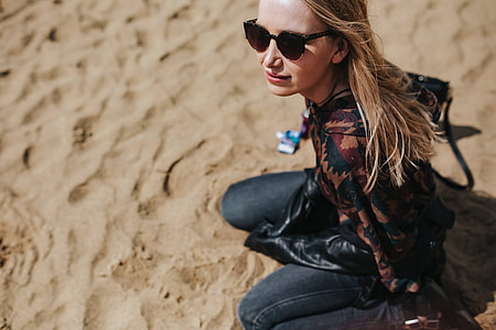 Young woman wearing a leather jacket and sunglasses on the beach thumbnail