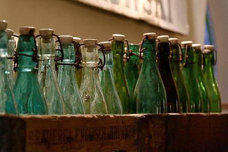 green glass bottles on brown wooden bottle holder thumbnail
