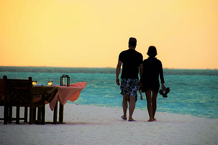 man and woman walking on beach thumbnail