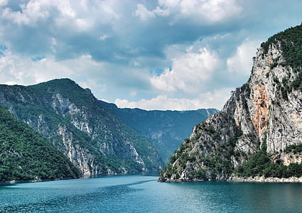 body of water surrounded by mountains thumbnail