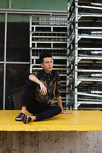 man sitting on yellow metal board thumbnail