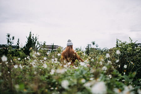 woman standing in green leaf plant field at daytime thumbnail
