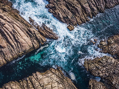 bird's eye view photography of photo of body of water rushing through rocks thumbnail