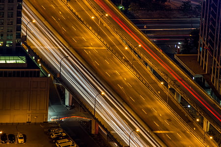 photo of gray concrete road in between building during nighttime thumbnail