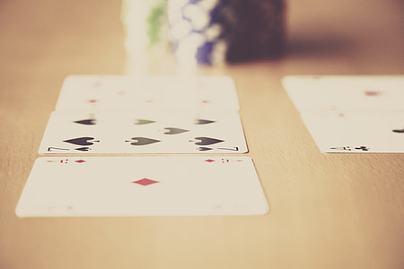 five playing cards beside poker chips thumbnail
