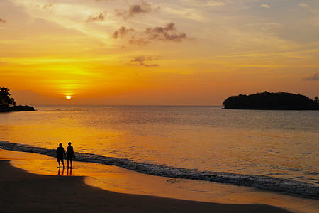 two person standing on seashore during golden hour thumbnail