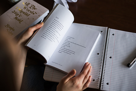 person opening book near table thumbnail