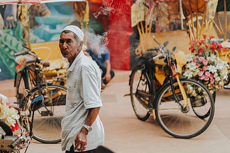 man standing near black bicycles with bouquet of flower during daytime thumbnail