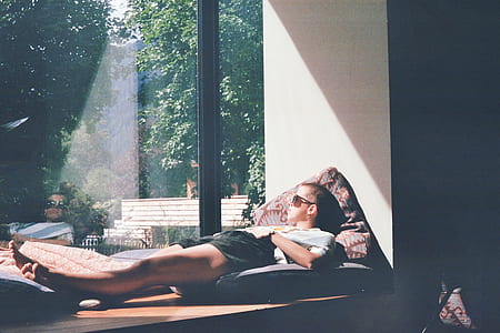 person laying on pillows facing the sunlight thumbnail