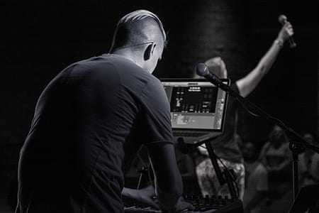 grayscale photography of man playing electronic keyboard thumbnail