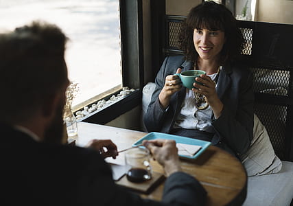 woman in black blazer sitting in front of a man thumbnail