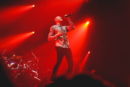 Man Wearing Grey Button-up Dress Shirt And Black Fitted Pants Holding Black Cordless Microphone thumbnail