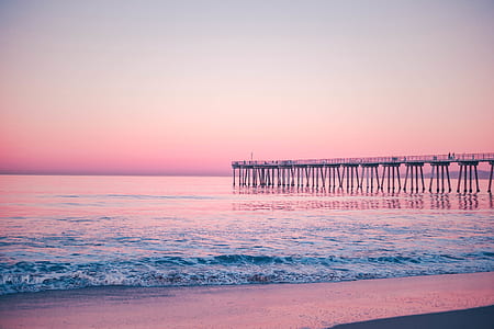 gray wooden dock near bodies of water under blue sky at sunset thumbnail