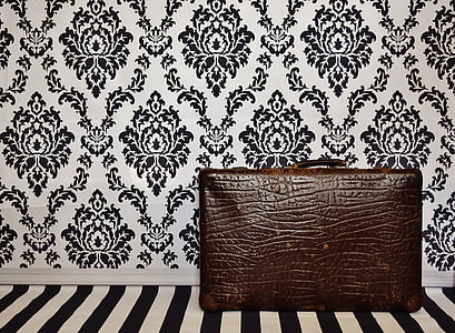 brown leather bag beside floral wallapper thumbnail