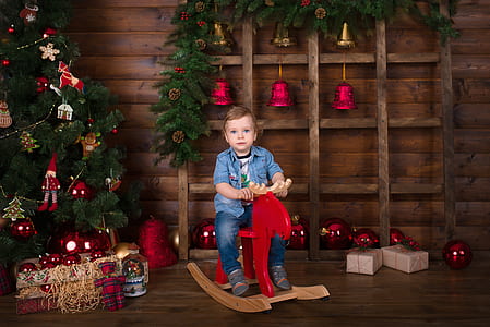 boy riding red moose rocker thumbnail