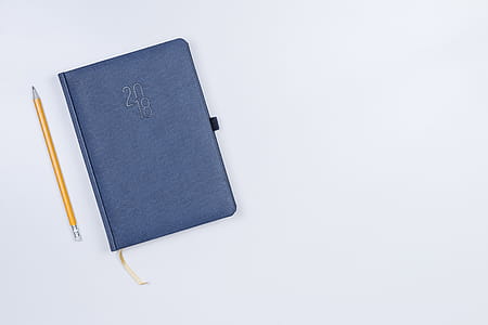 Pretty diary with a pencil on the white table. thumbnail
