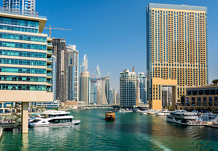 yachts on body of water near high rise buildings thumbnail