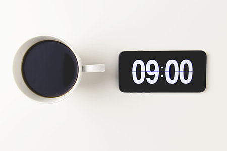 Cup of coffee with the time displayed on mobile iPhone smartphone clock thumbnail