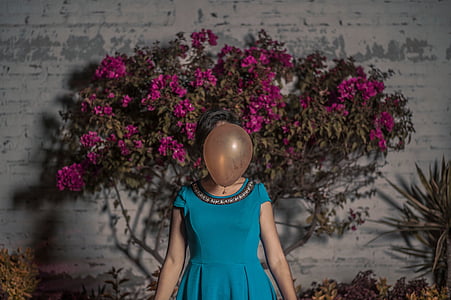 woman standing in front og purple petaled flowers thumbnail