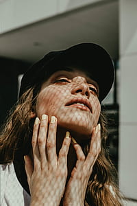 woman holding her neck and closing her eyes behind white concrete building thumbnail