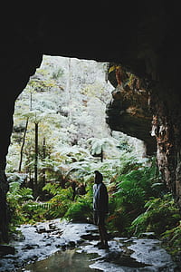man standing at cave entrance thumbnail