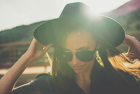 woman holding black cowboy hat thumbnail