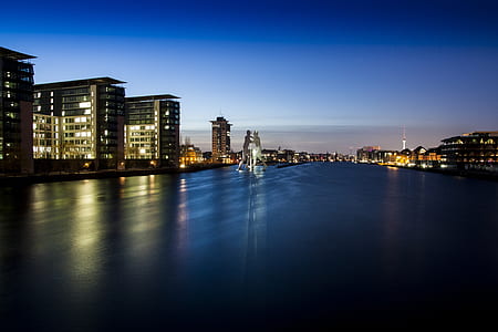 photograph of city structures beside body of water thumbnail