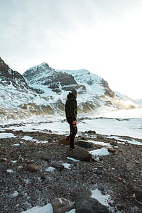 man walking on mountain covered by snow thumbnail