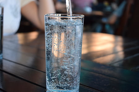 almost-full drinking glass on brown table thumbnail