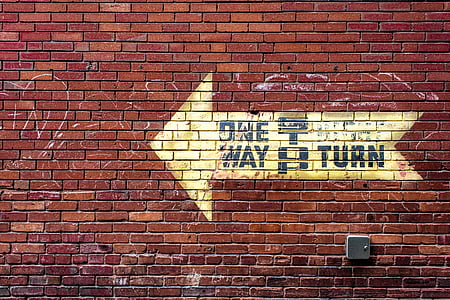 One Way signage on red brick wall thumbnail