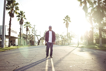 man standing between palm trees thumbnail