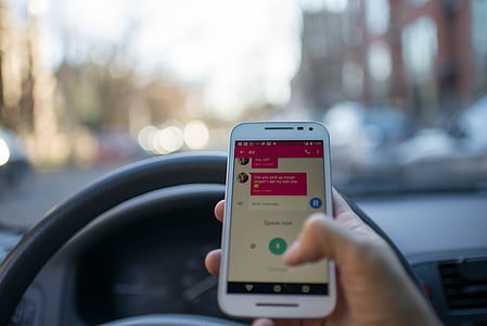 selective focus photography of person using smartphone inside vehicle thumbnail