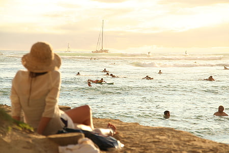 woman looking at people swimming in beach during sunset thumbnail