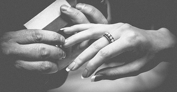 gray scale photography of human hand with rings thumbnail