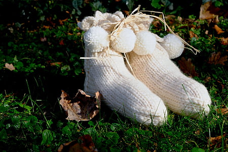 pair of white knitted shoes in green grass thumbnail
