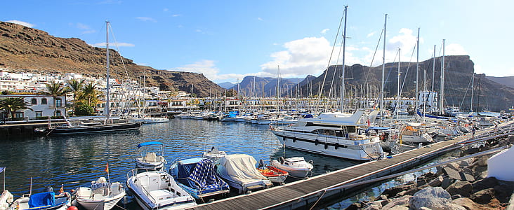 assorted boats and yachts on water under blue sky across mountain during daytime thumbnail
