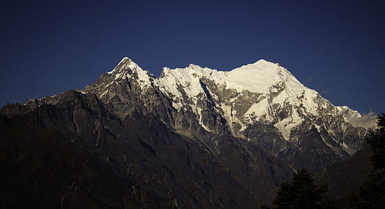 photo of ice covered rocky mountain during clear blue sky daytime thumbnail