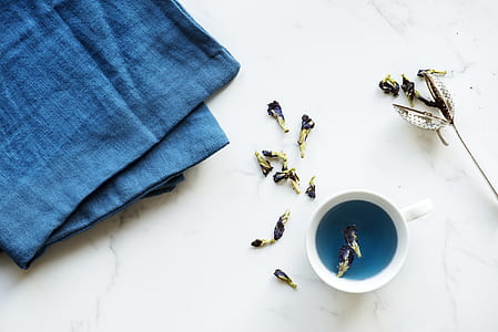 flat lay photography of white mug beside blue mat thumbnail