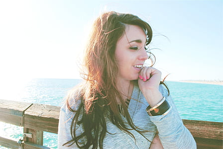 woman sitting near body of water during daytime thumbnail