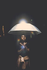 Woman Holding Illuminated Lamp at Night thumbnail