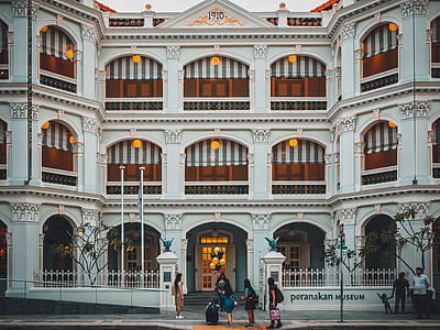 people in front of white and brown building during day thumbnail