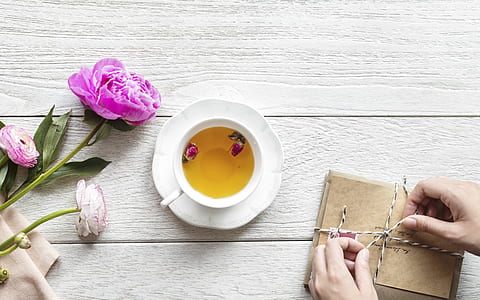 white teacup filled with yellow liquid on white saucer thumbnail
