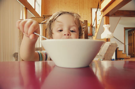 baby in front of white bowl on red surface thumbnail