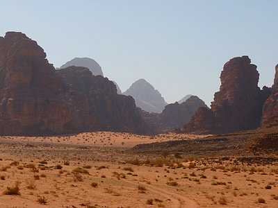 brown and grey rock formation landscape surrounded by beige sands thumbnail