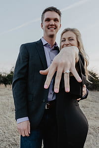 man standing beside woman shower her hand with silver-colored ring thumbnail